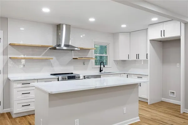 a kitchen with stainless steel appliances granite countertop a sink a stove and a refrigerator