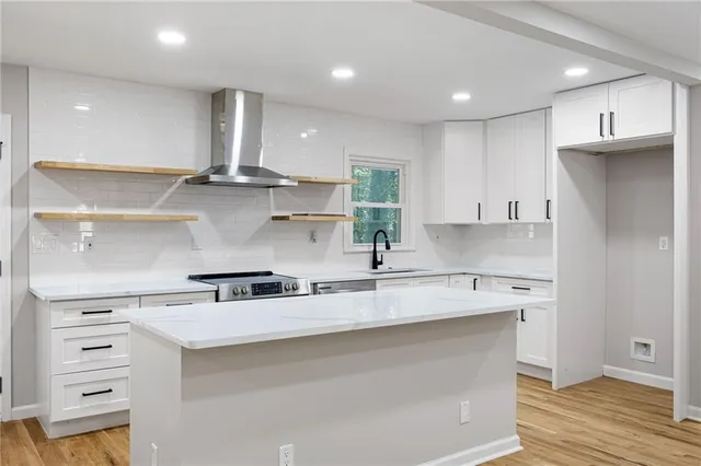 a kitchen with stainless steel appliances granite countertop a sink a stove and a refrigerator