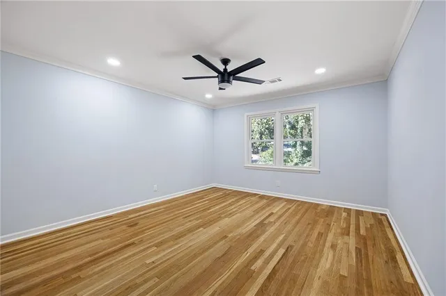 an empty room with windows and ceiling fan