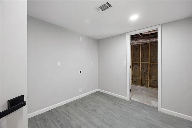 an empty room with wooden floor and closet