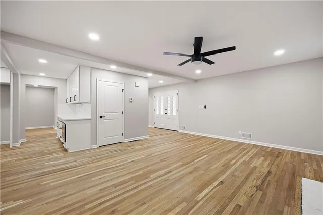 a view of an empty room and kitchen view