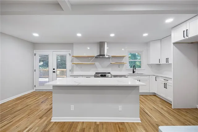 a kitchen with stainless steel appliances granite countertop a sink a stove and a refrigerator