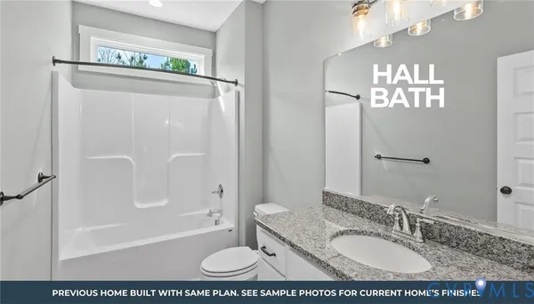 a bathroom with a granite countertop sink a mirror a bathtub and shower