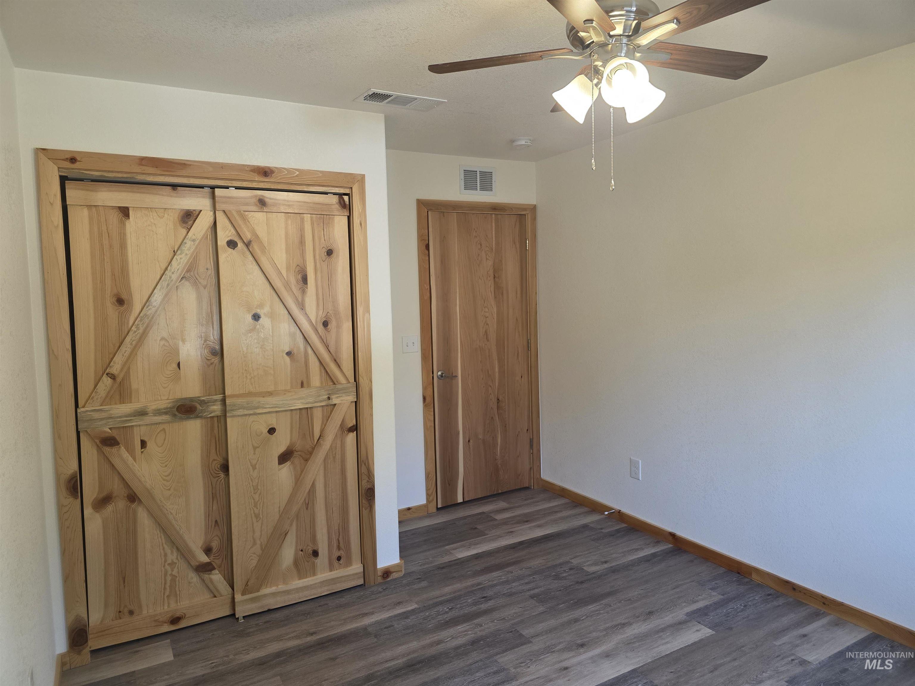 4157 Highway 12 Kamiah, ID 83536 - Photo 26 of 40 Unfurnished bedroom featuring a ceiling fan and dark wood-type flooring