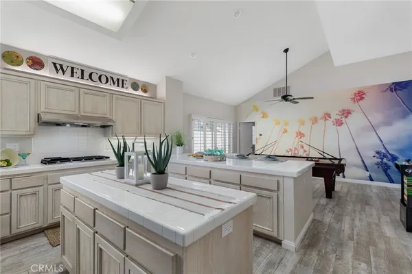 a kitchen with kitchen island a counter top space a sink stainless steel appliances and cabinets