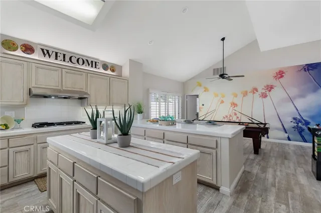 a kitchen with kitchen island a counter top space a sink stainless steel appliances and cabinets