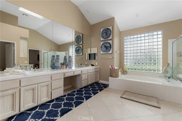 a bathroom with a double vanity sink a mirror a and a bathtub