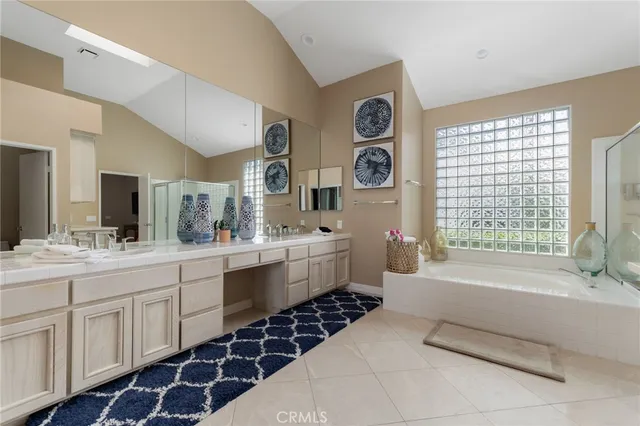 a bathroom with a double vanity sink a mirror a and a bathtub