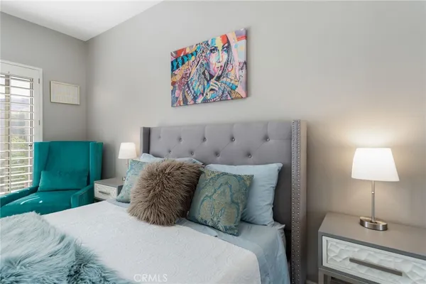 a bedroom with a bed and a lamp on dresser