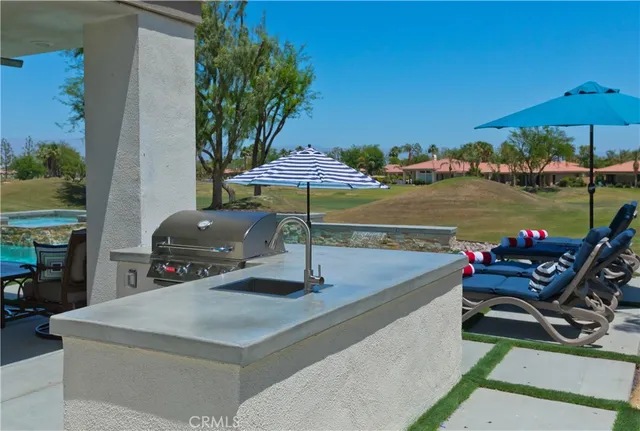 a view of a swimming pool with a table and chairs under an umbrella