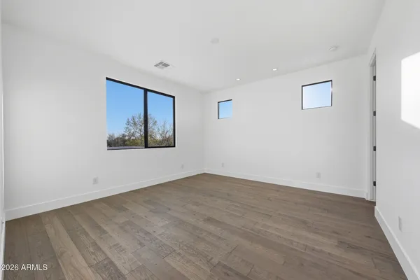 a view of an empty room with wooden floor