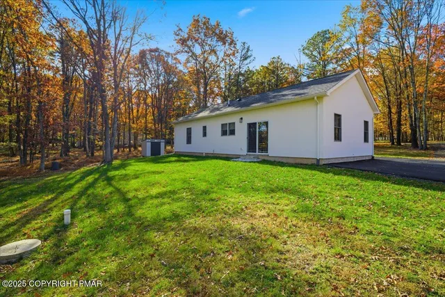 a view of a house with a yard and sitting area