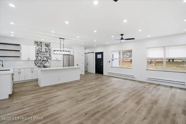 a large white kitchen with kitchen island a sink a stove and a refrigerator