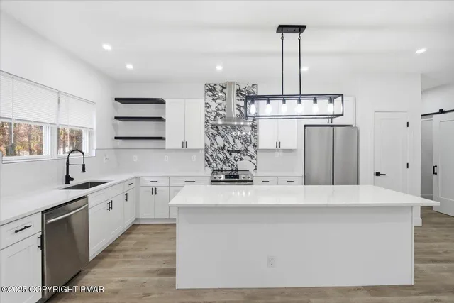 a large kitchen with kitchen island stainless steel appliances a counter space and cabinets