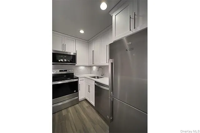 a kitchen with stainless steel appliances granite countertop a refrigerator and a sink
