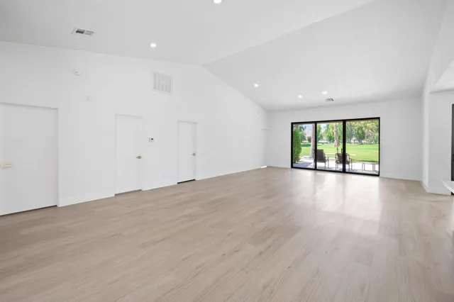 an empty room with wooden floor and window