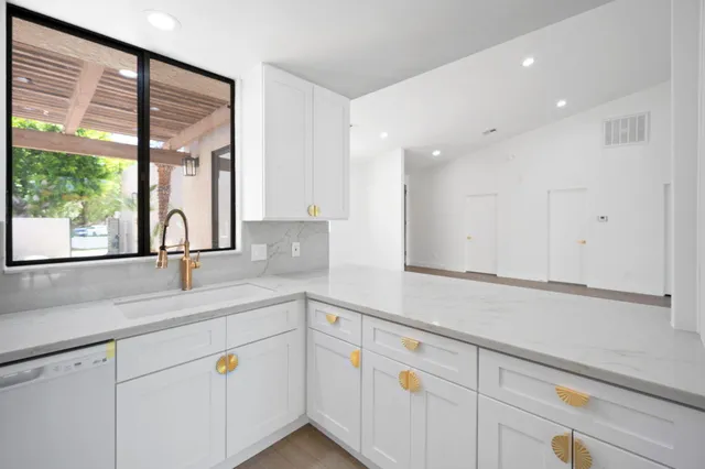 a kitchen with appliances cabinets and a large window