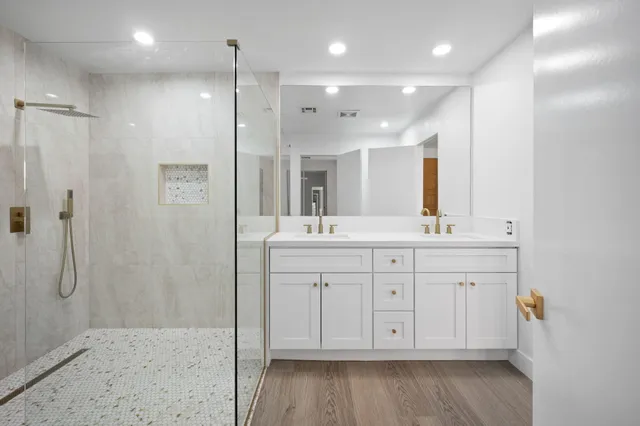 a spacious bathroom with a shower a sink and a mirror