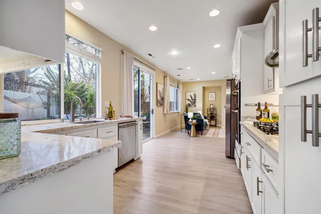 a large white kitchen with stainless steel appliances lots of counter top space