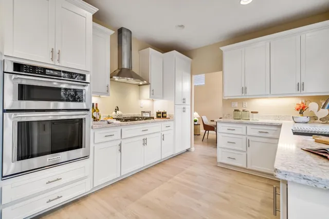 a kitchen with granite countertop white cabinets and white appliances
