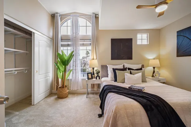 a bedroom with bed and balcony view