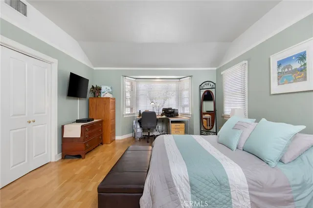 a bed room with bed and a flat tv screen