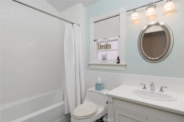 a bathroom with a granite countertop sink mirror vanity and toilet