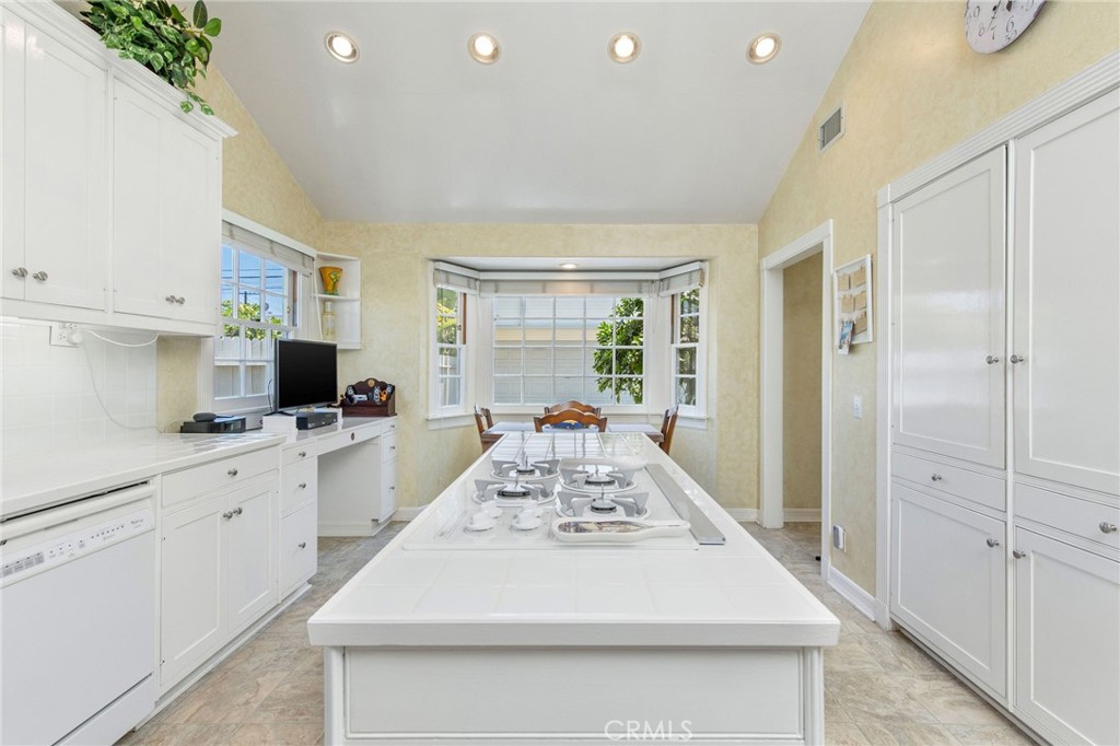 4124 East 5th Street Long Beach, CA 90814 - Photo 30 of 38 a large white kitchen with kitchen island a stove a refrigerator a sink dishwasher and white cabinets with wooden floor