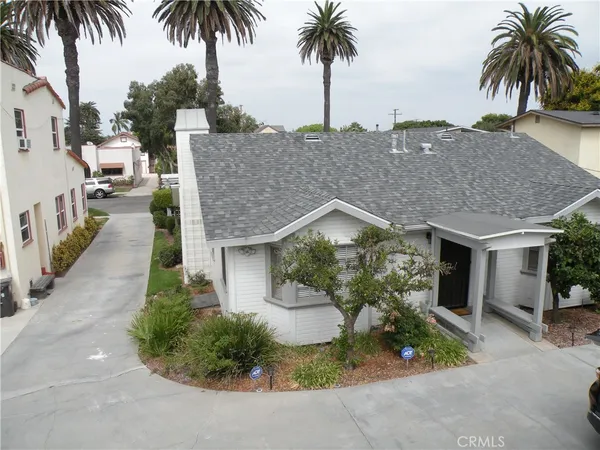 front view of a house with a yard and potted plants