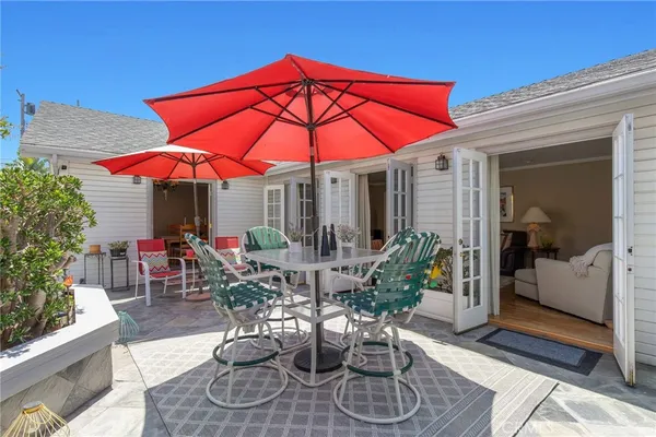 a view of the patio with chairs and table under an umbrella