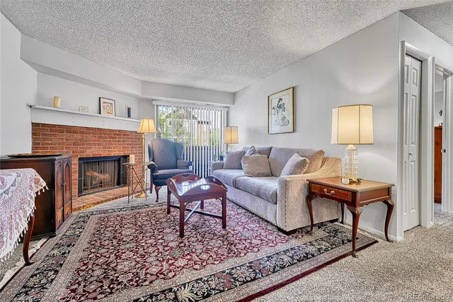 a living room with furniture a fireplace and a table
