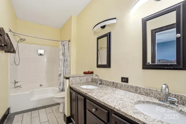 a bathroom with a granite countertop sink mirror and a bath tub