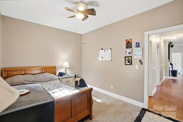a bedroom with furniture and a chandelier fan