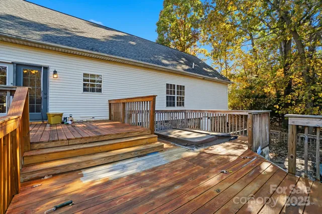 a view of a deck with wooden floor and fence next to a yard