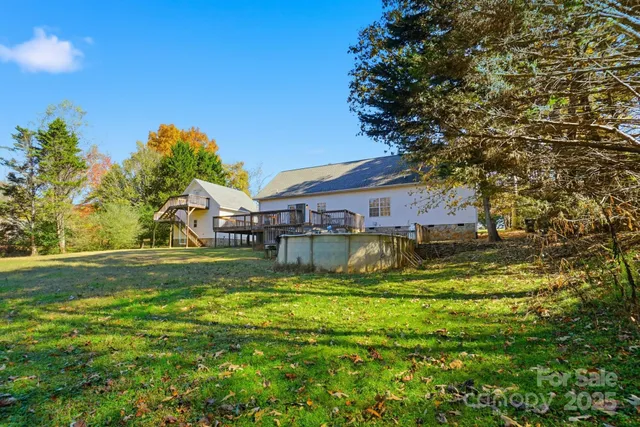 a view of a house with a big yard potted plants and large tree
