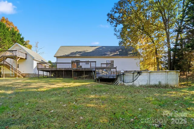 a view of a house with pool and a big yard