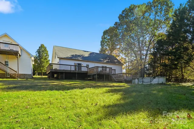 a view of a house with a big yard potted plants and large tree