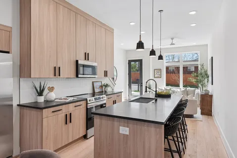 a kitchen with white cabinets a sink dishwasher and a stove with wooden floor
