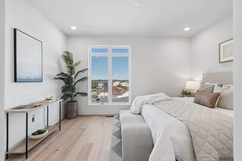 a bedroom with a large bed and a potted plant