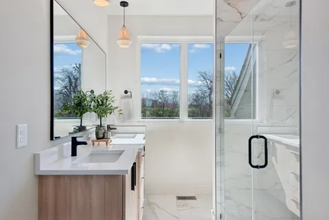 a bathroom with a double vanity sink mirror and bathtub