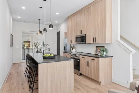 a kitchen with stainless steel appliances granite countertop a stove a sink and a refrigerator