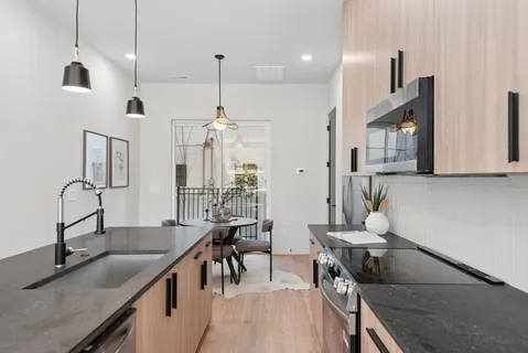 a kitchen with stainless steel appliances granite countertop a sink stove and refrigerator