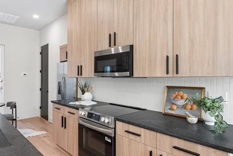 a kitchen with stainless steel appliances a sink a stove and a microwave