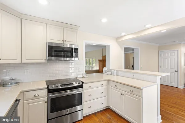 a kitchen with stainless steel appliances white cabinets and a sink