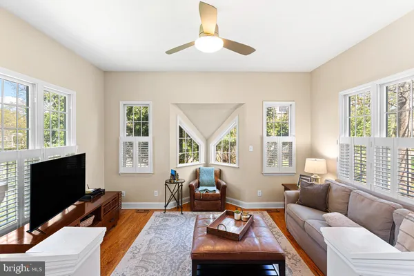 a living room with furniture a large window and a flat screen tv