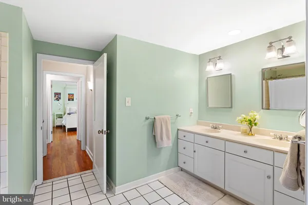 a spacious bathroom with 2 sink and a mirror