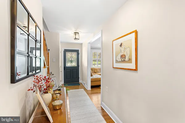 a hallway with beautiful frames and flower vase