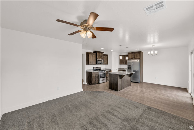 5875 Challenger Way St. George, UT 84790 - Photo 6 of 18 Open-concept living area with a ceiling fan, plush gray carpeting, and wood-finish flooring