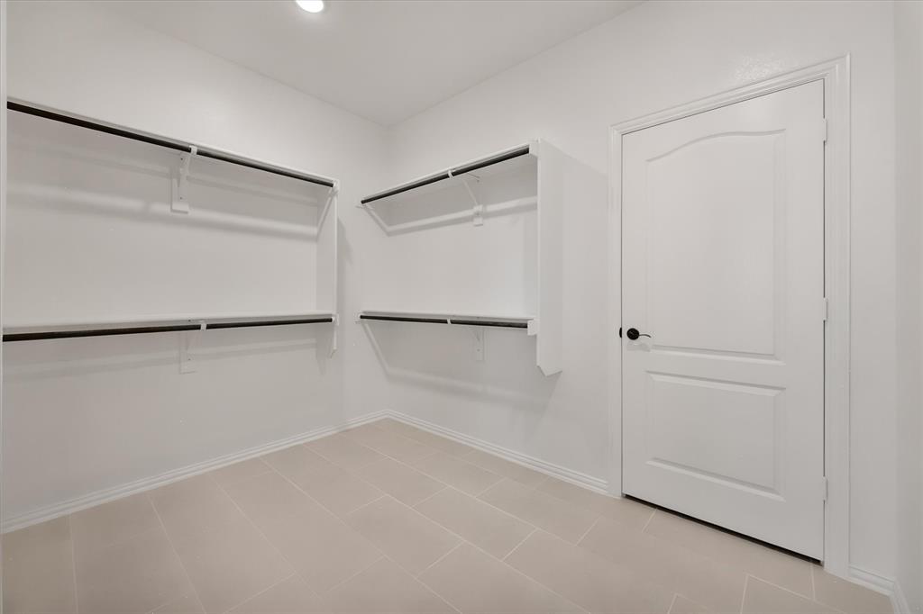 5626 Rutherford Drive Midlothian, TX 76065 - Photo 23 of 37 The primary walk-in closet — double hanging rods on both walls, so there's room for every season's wardrobe.