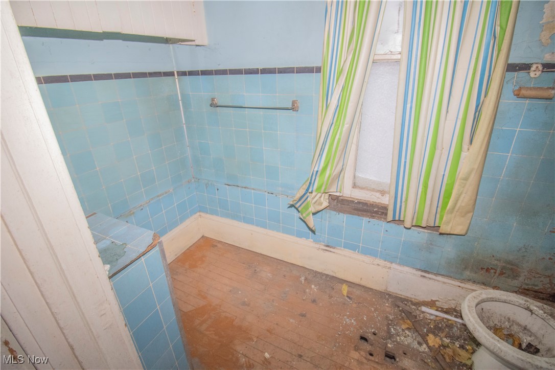 3486 Kimmel Road Cleveland, OH 44105 - Photo 6 of 12 Bathroom with tile walls, a wainscoted wall, and vanity